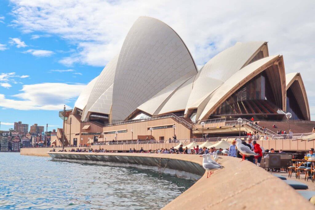 image of the opera house in sydney with people gathered outside