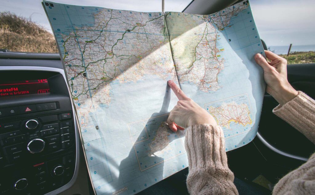 a woman looking at a road map, trying to figure out which way to go.