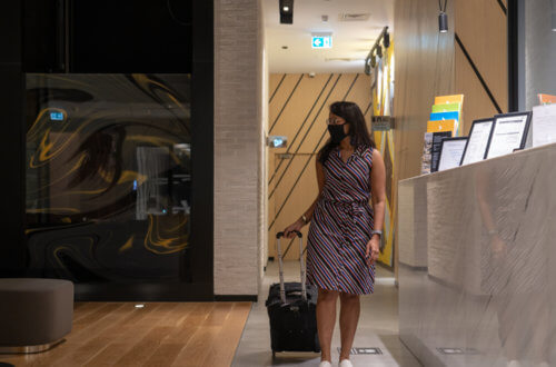 woman walking in a hotel lobby with a trolley bag