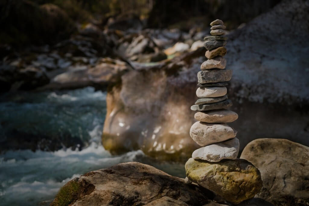 an image of more than 10 peoples or stones stacked up one above the other, indicating balance