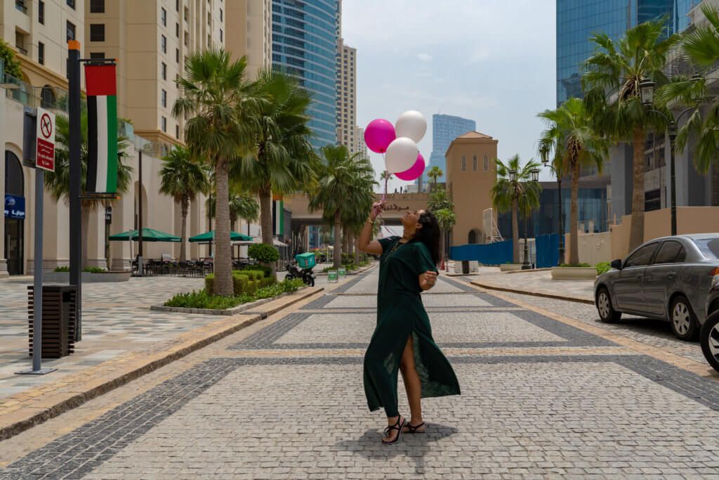 girl standing on the streets with balloons